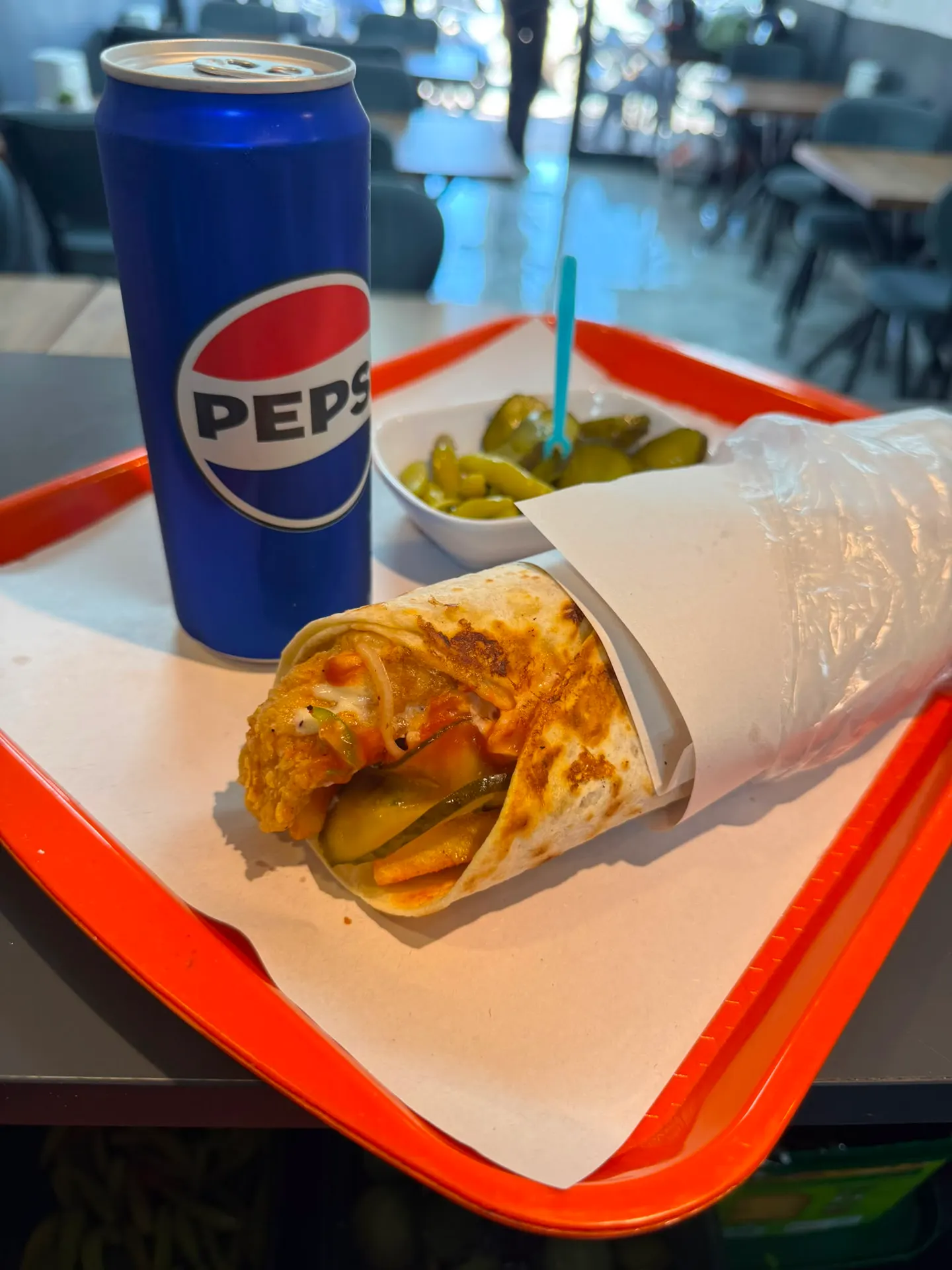 Çıtır tavuklu dürüm, yanında turşu ve kutu Pepsi